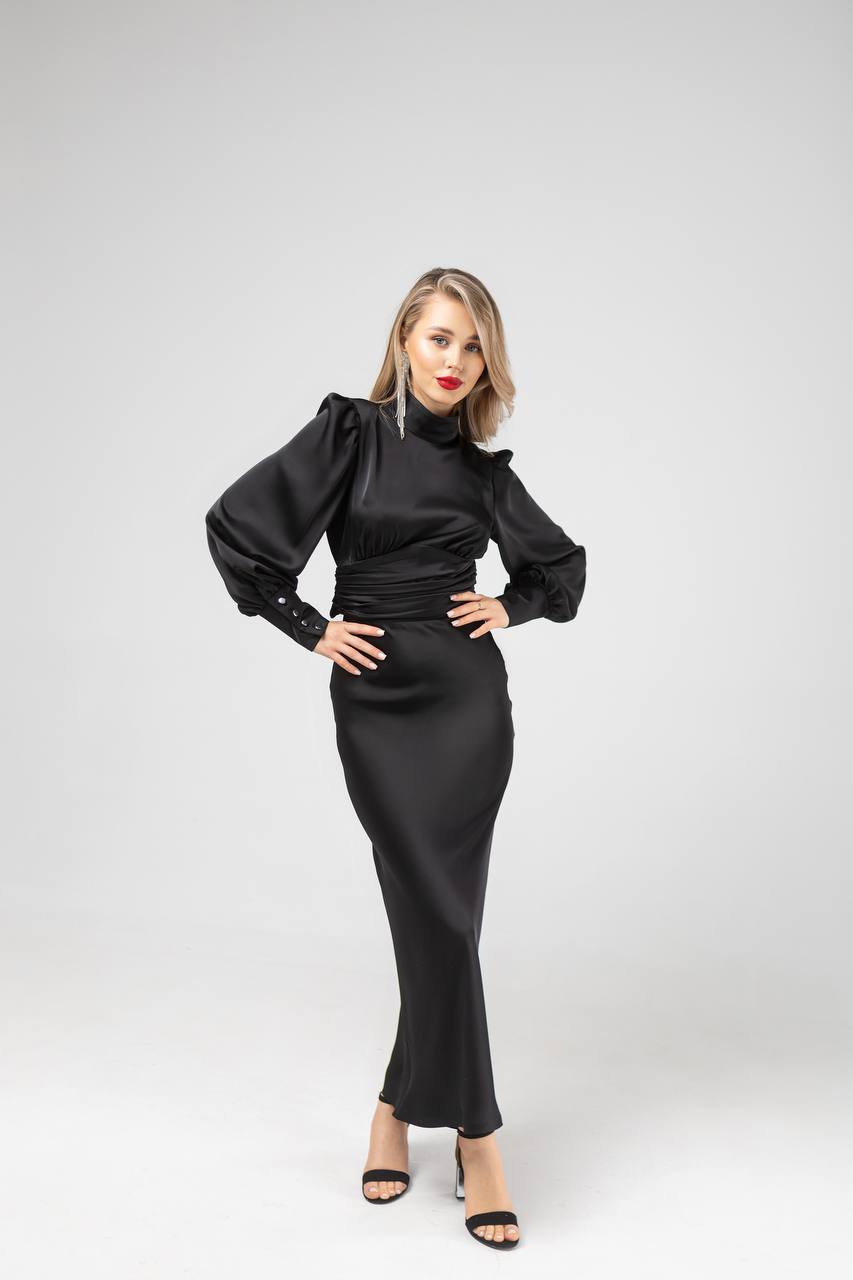 Woman wearing a black dress with puffed sleeves on a white background