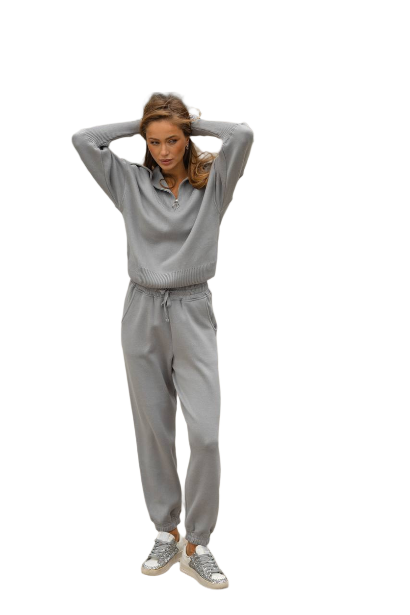 Woman wearing a gray tracksuit on a white background