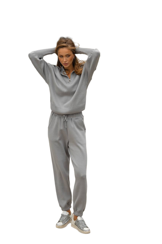 Woman wearing a gray tracksuit on a white background