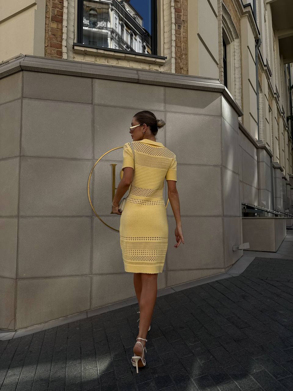 Woman in a yellow dress walking on a city street.