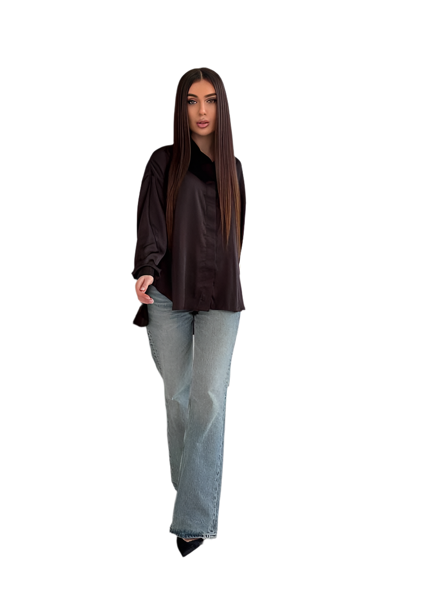 Woman wearing a black top and light blue jeans on a white background