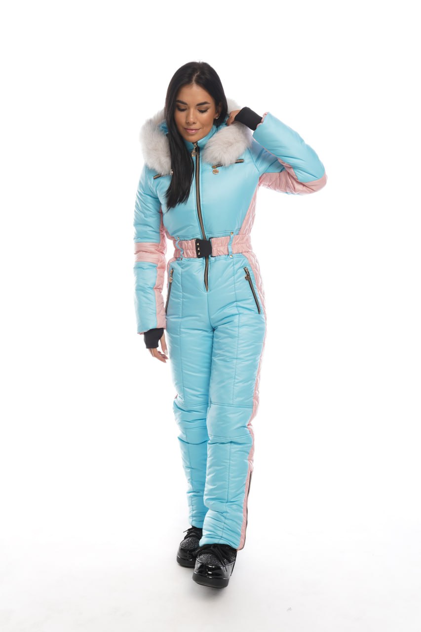 Woman wearing a light blue ski suit with pink accents on a white background