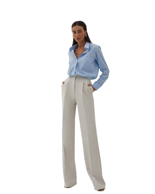 Woman wearing a light blue shirt and beige pants on a white background
