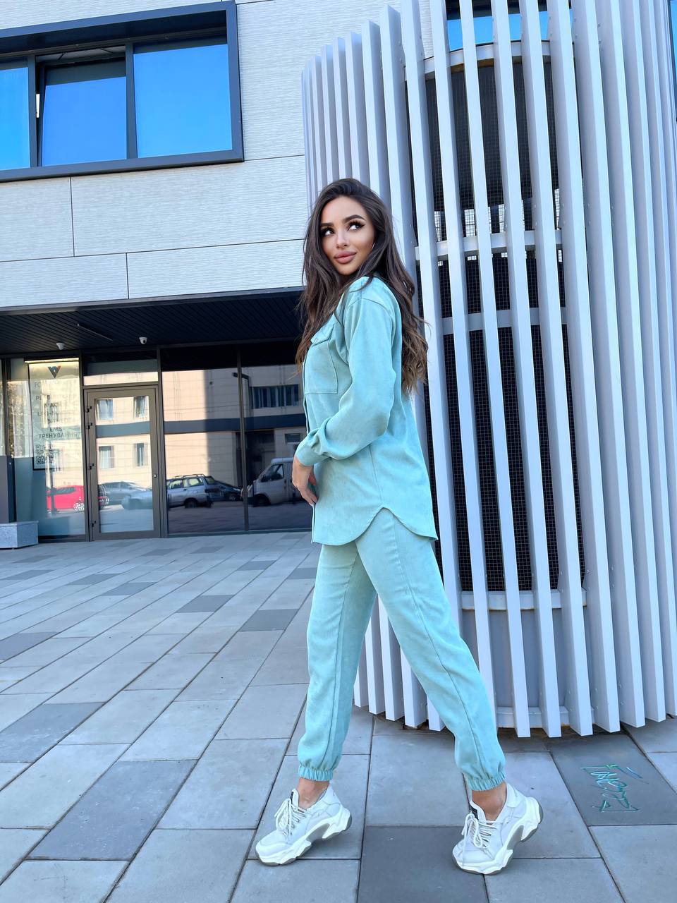 Woman in a light blue outfit standing in an urban setting