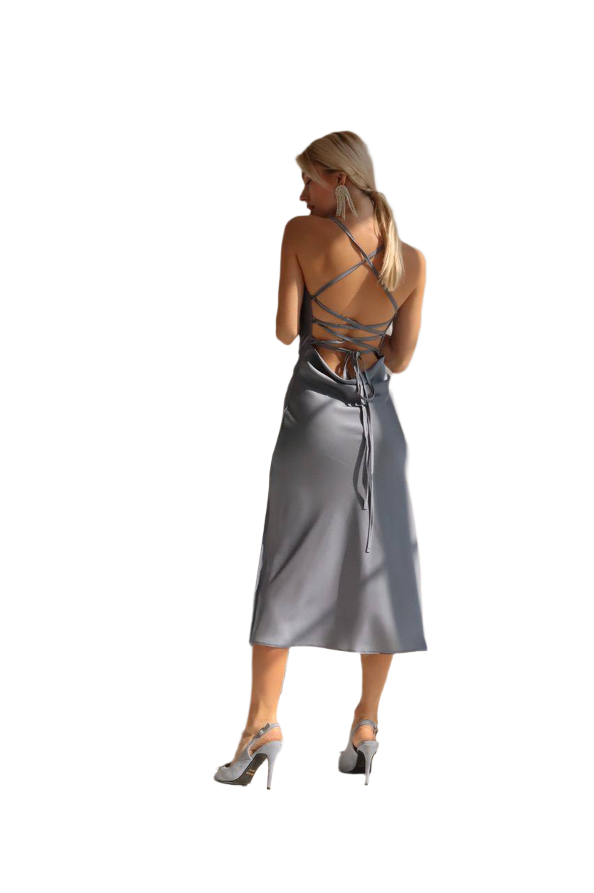 Woman wearing a silver dress with a backless design on a white background