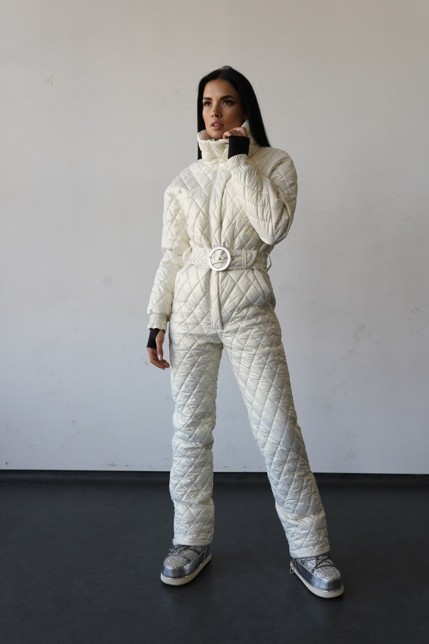 Person wearing a white quilted snowsuit against a plain background