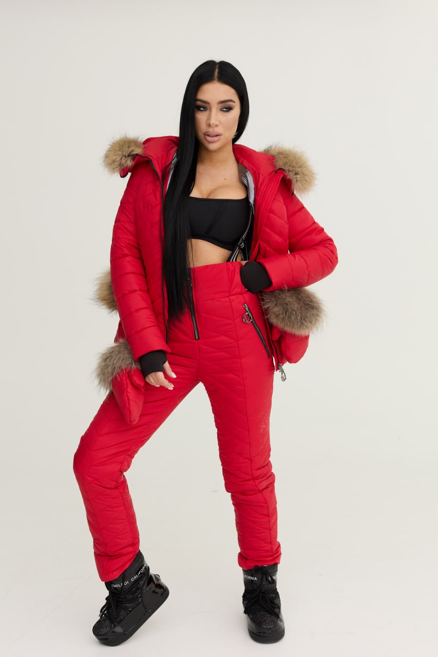 Person wearing a red puffer outfit with fur trim on a white background