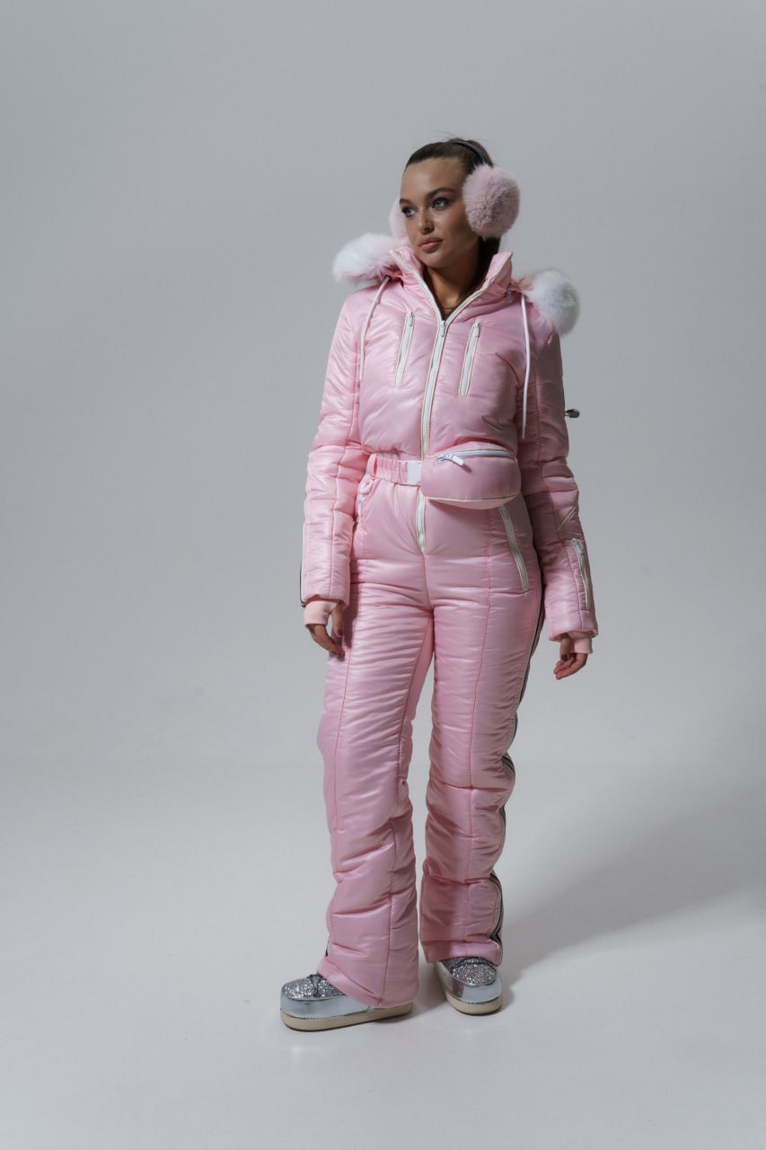 Person wearing a pink puffer suit with fur trim on a plain background