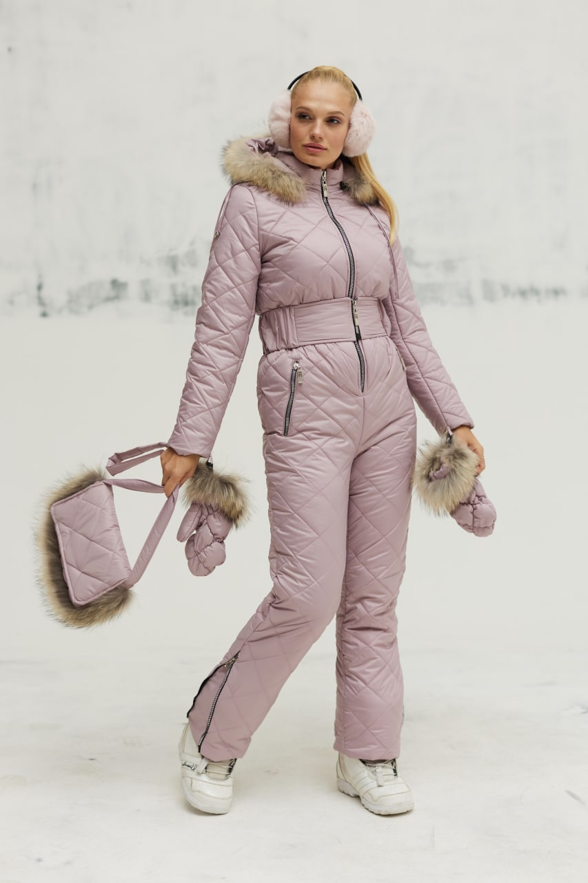 Person wearing a pink winter outfit with fur accents on a snowy background