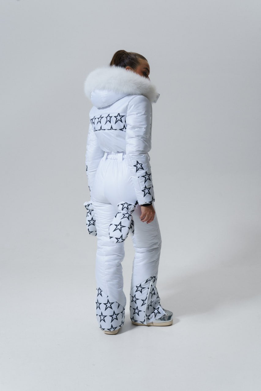 Person wearing a white puffer suit with star patterns on a plain background
