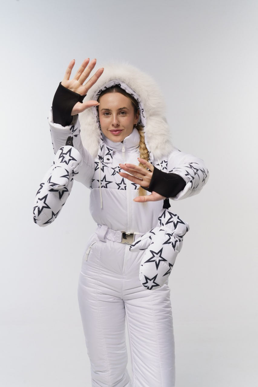 Person wearing a white and black star-patterned snowsuit with a hood on a light gray background