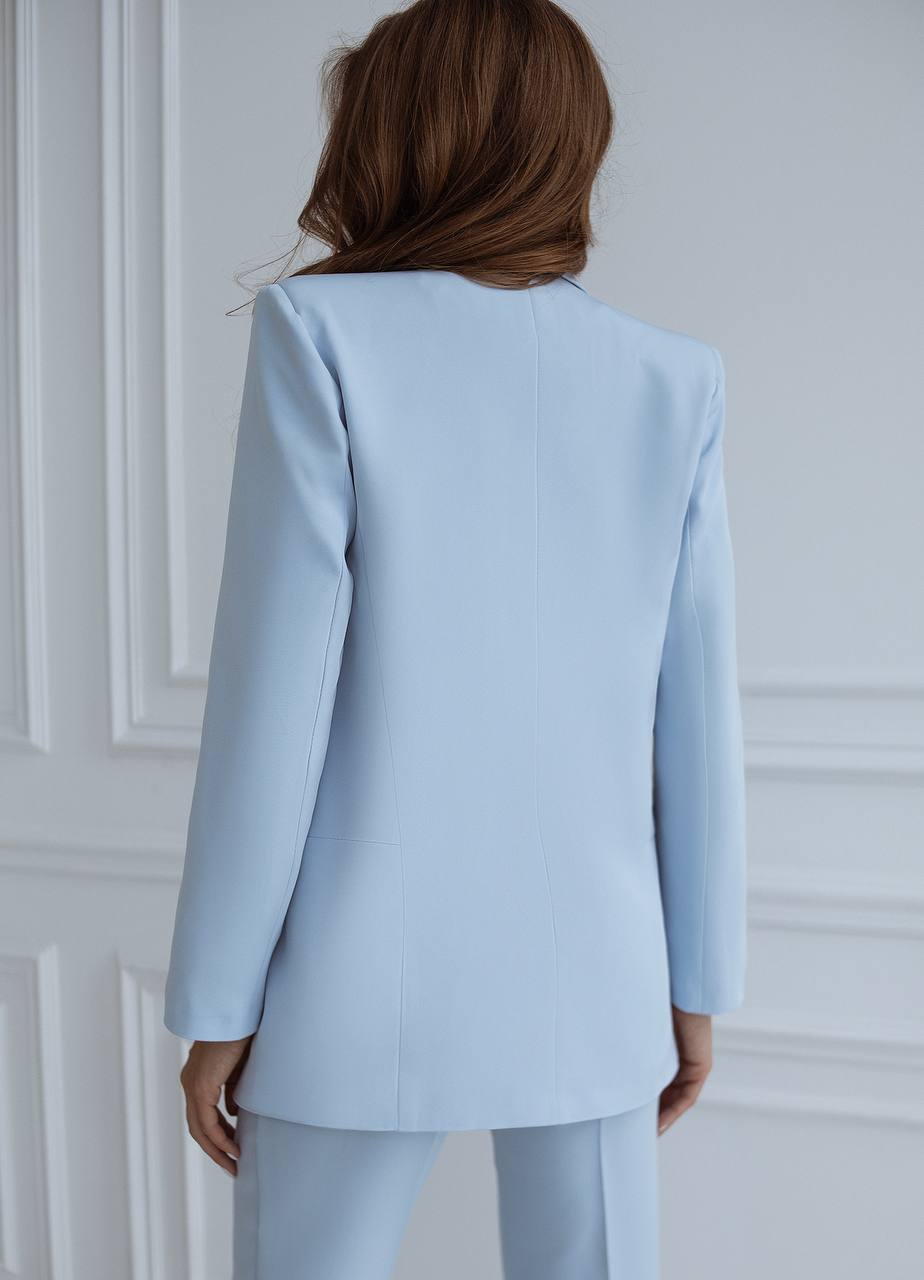 Light blue suit worn by a person against a white wall