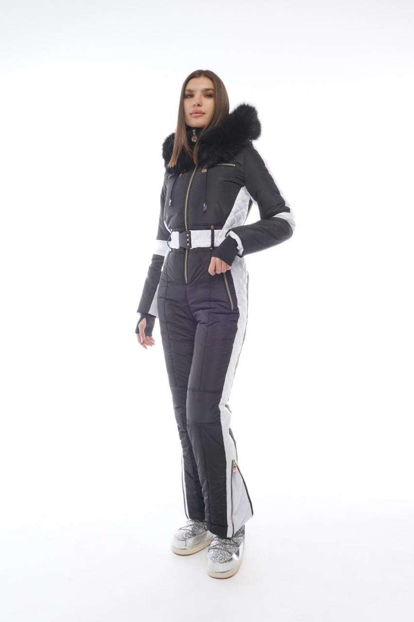 Woman wearing a gray and black ski suit with white accents on a white background