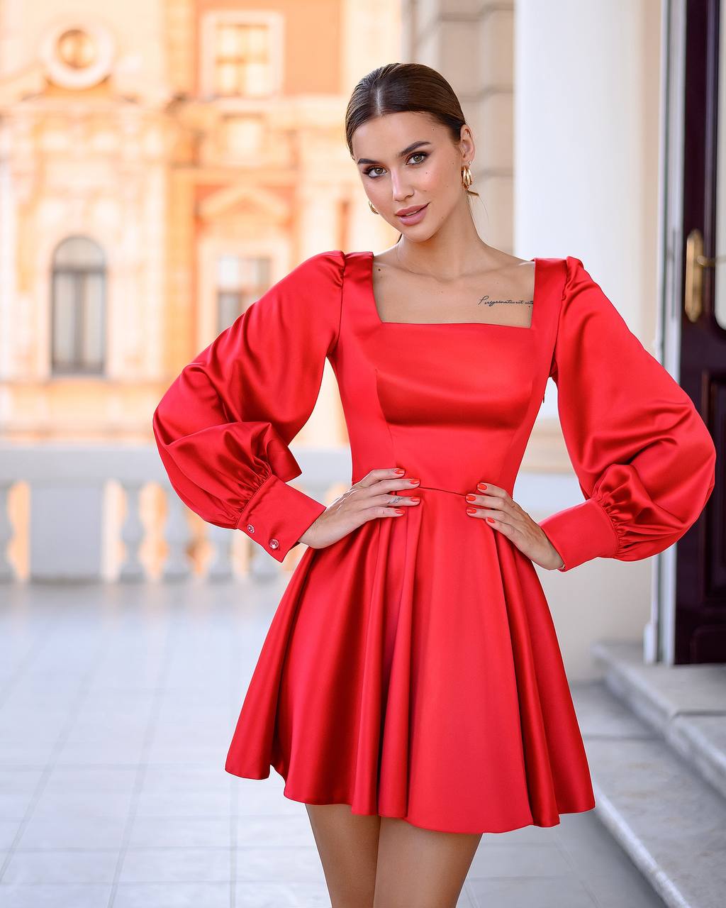Woman wearing a red dress with long sleeves in an outdoor setting