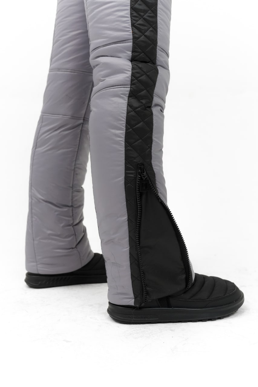 Gray insulated pants with black zippers and foot covers on a white background