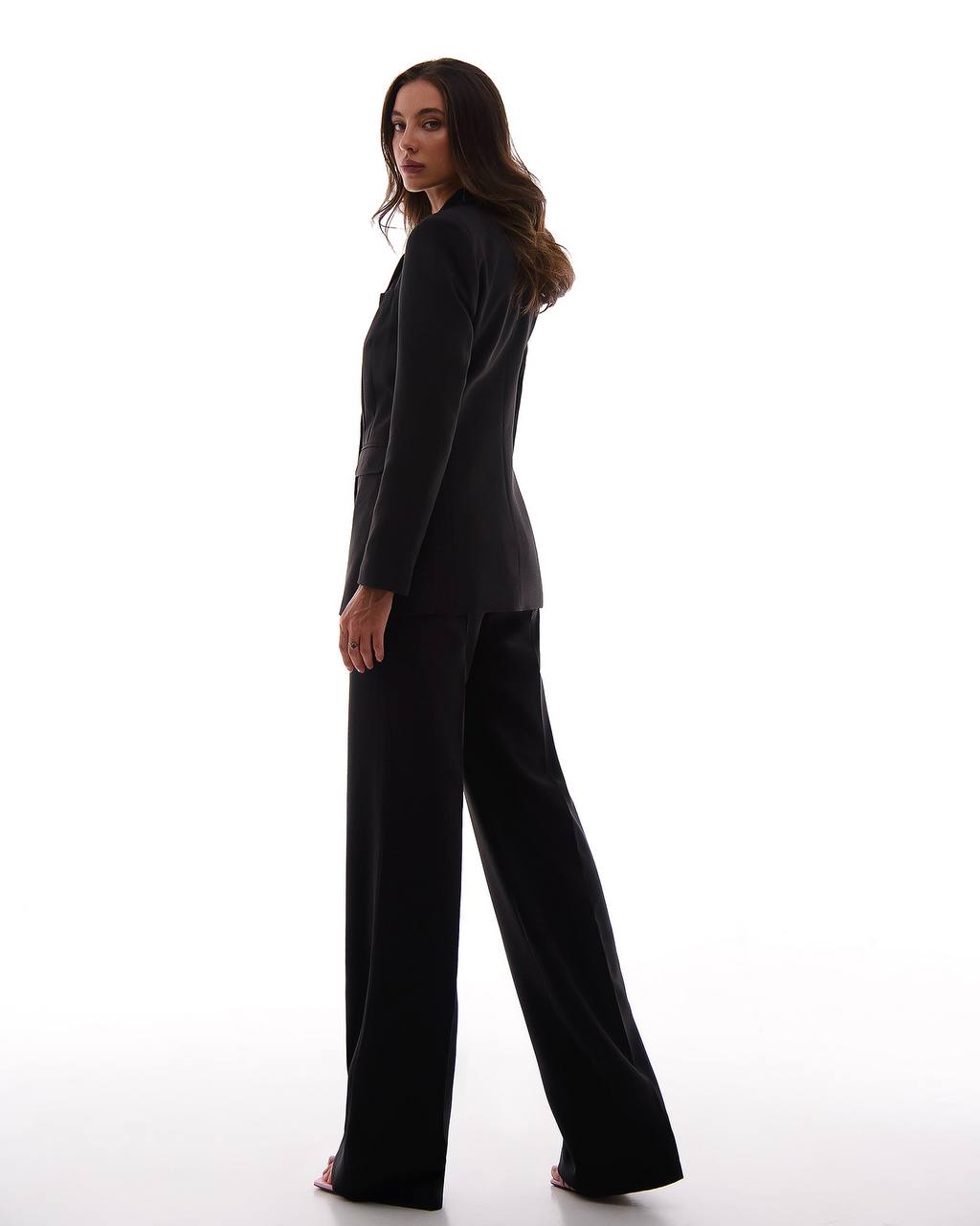 Woman wearing a black suit on a white background