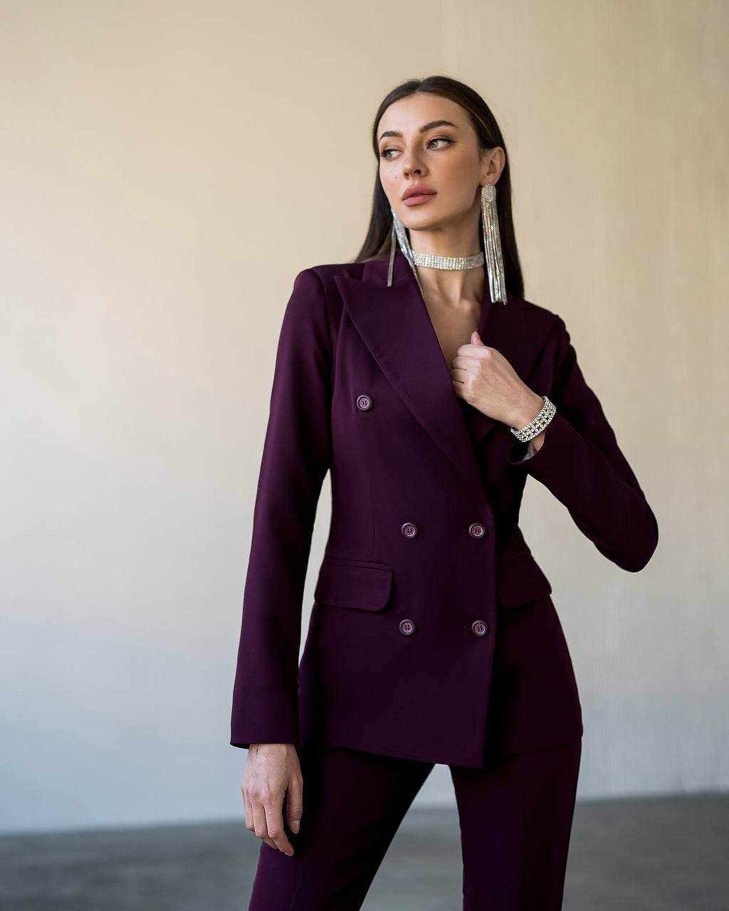 Woman wearing a purple suit with a neutral background