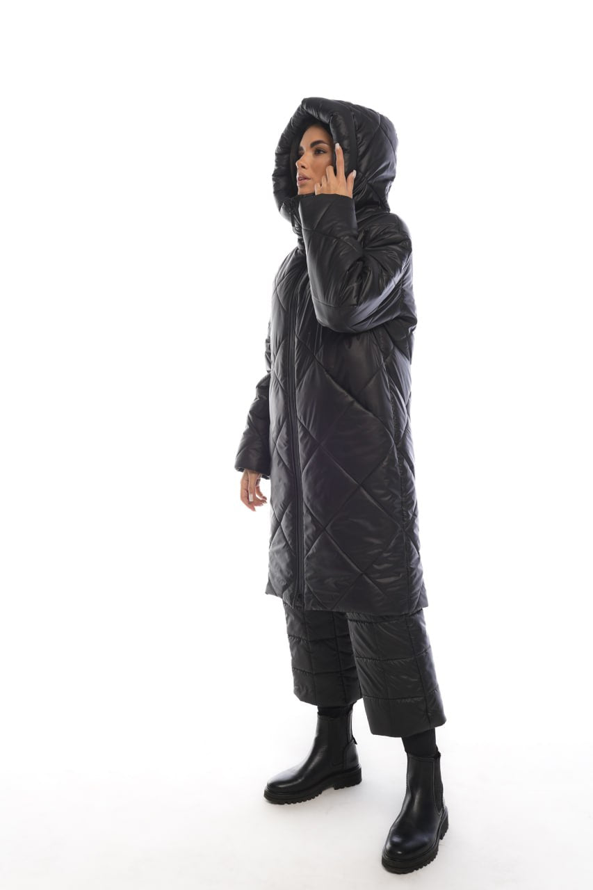 Person wearing a black quilted jacket on a white background