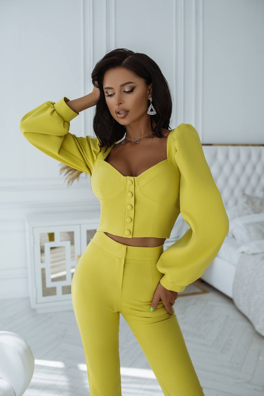 Woman wearing a bright yellow outfit in a white room