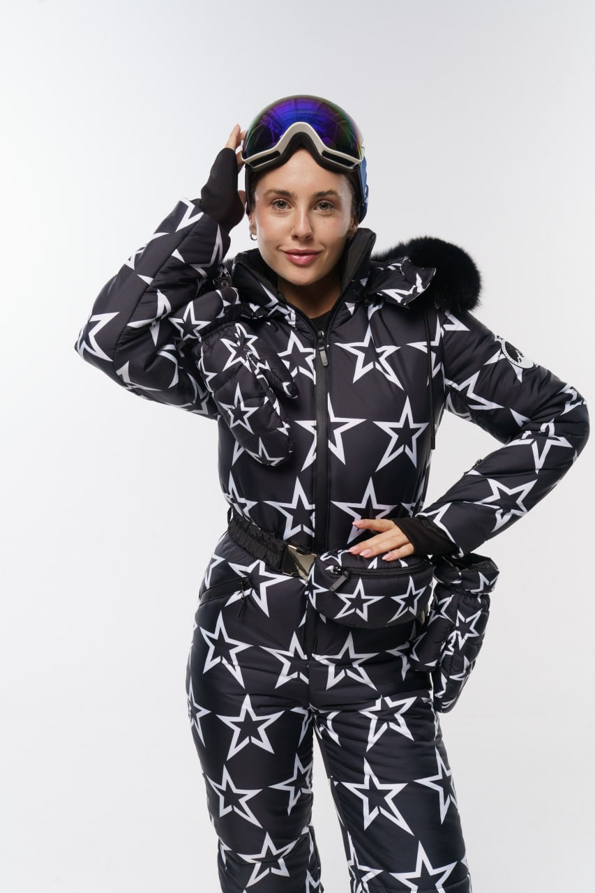 Person wearing a black snowsuit with white star pattern on a white background