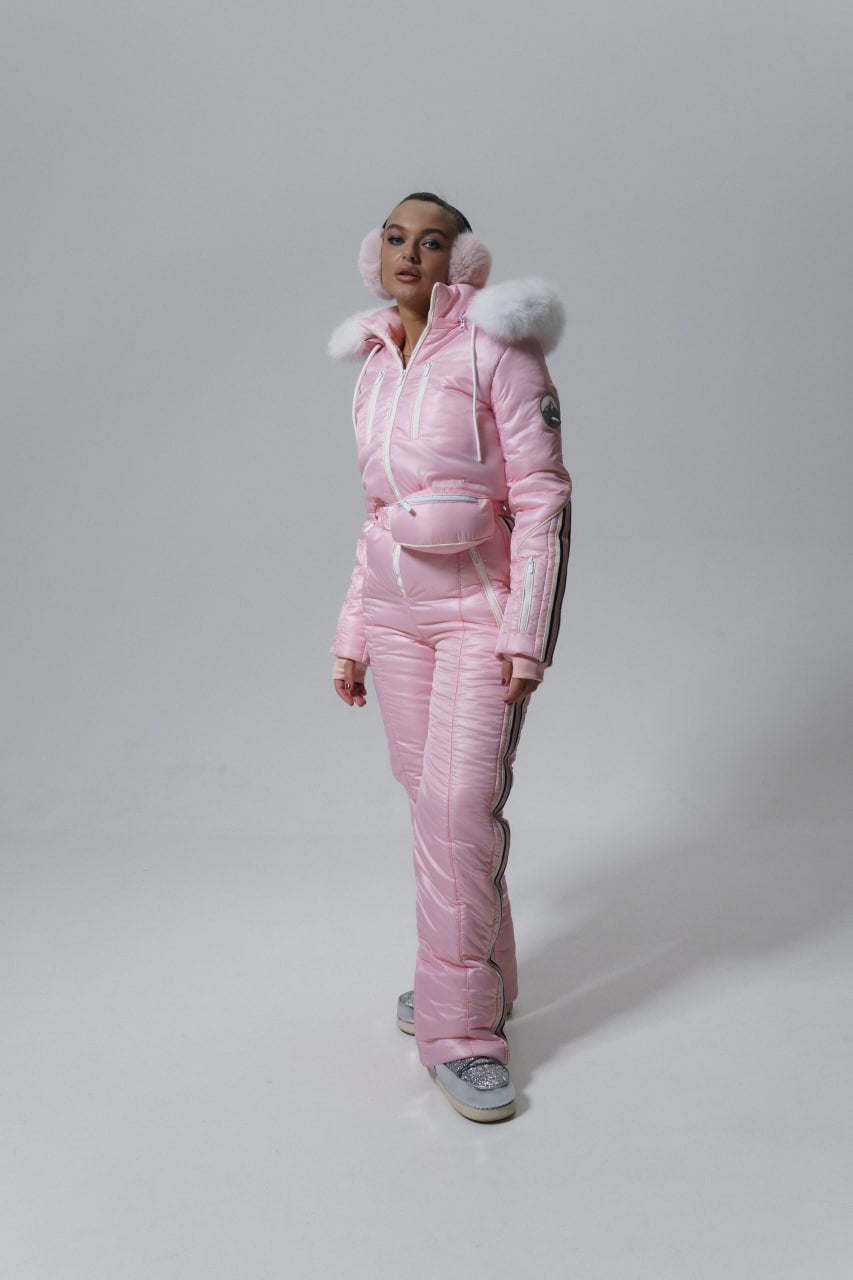 Person wearing a pink puffer suit with fur-lined hood on a white background
