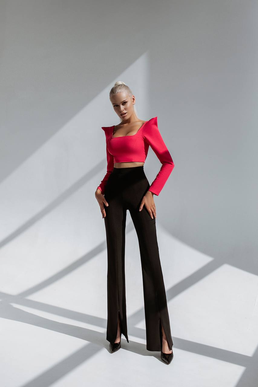 Person wearing a red top and black pants on a gray background