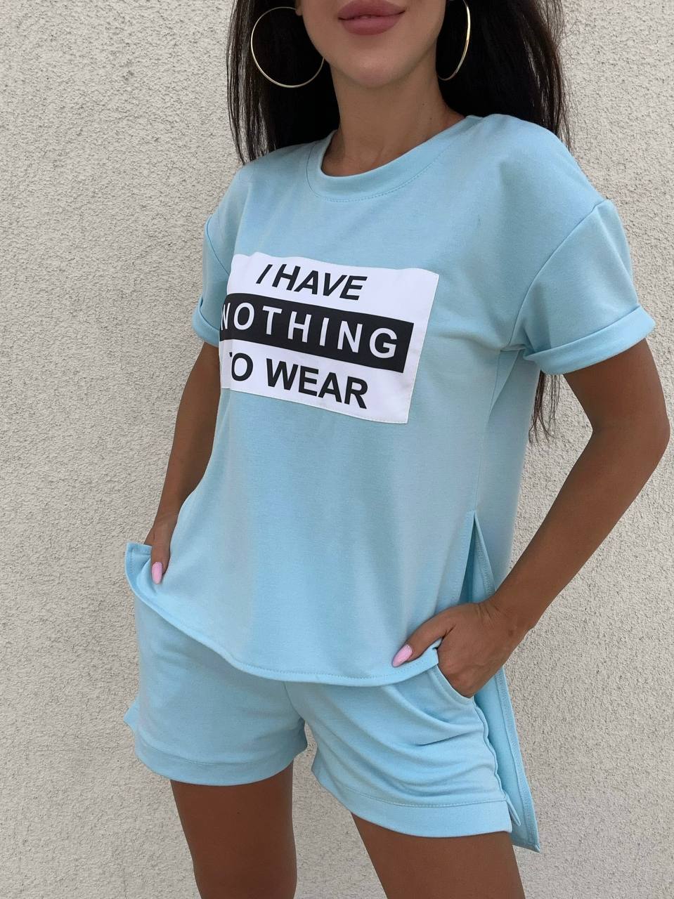 Person wearing a light blue t-shirt with a humorous text design against a plain background