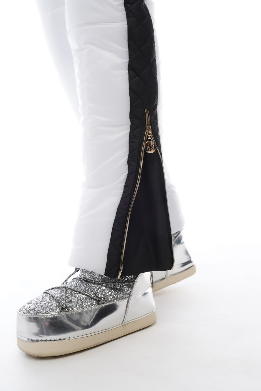 Silver glittery sneakers with a black and white pant leg on a white background
