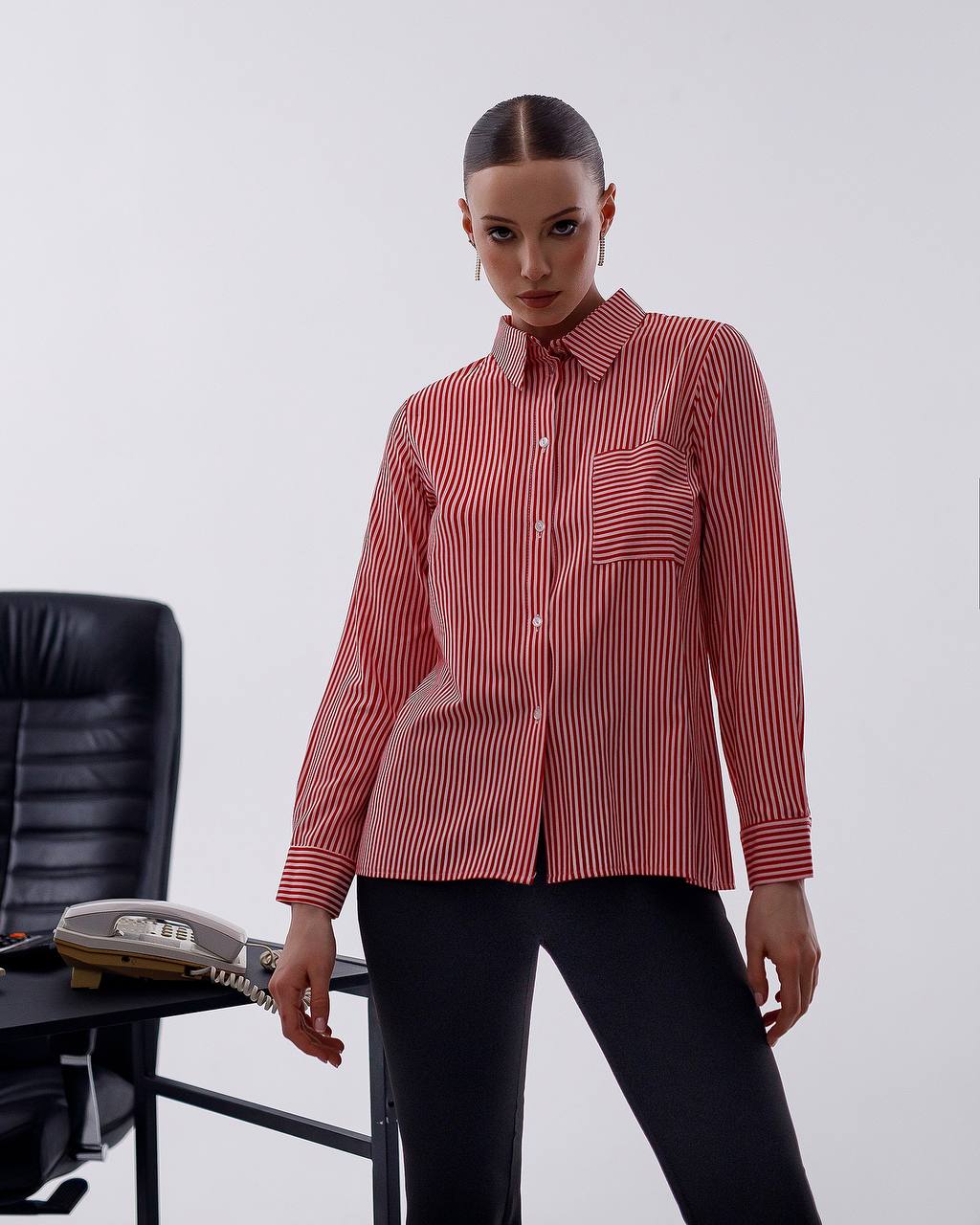 Person wearing a red and white striped shirt with a blurred office chair in the background