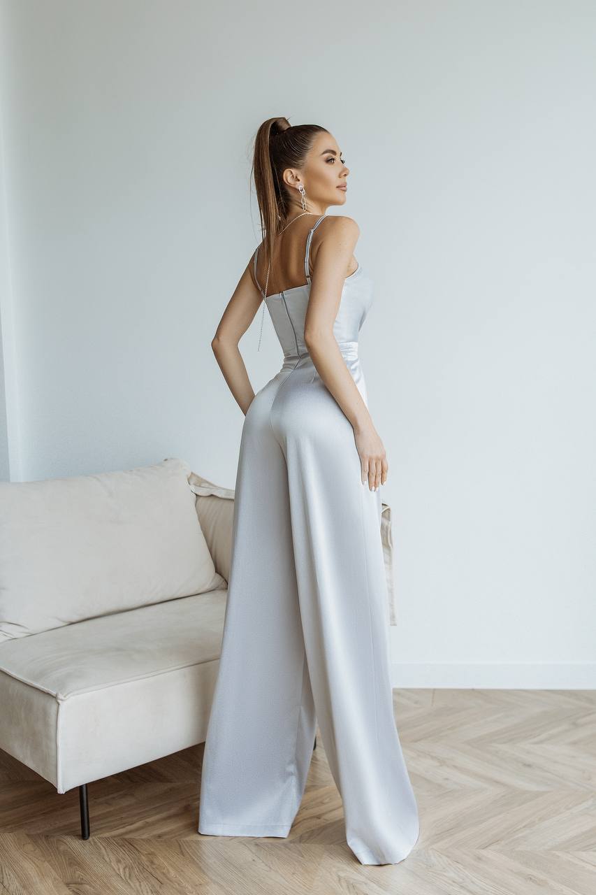 Woman in a white dress standing in a minimalistic room with a couch.