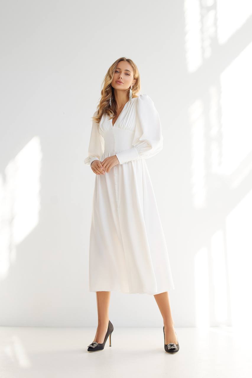 Woman wearing a white dress in a bright, minimalistic setting