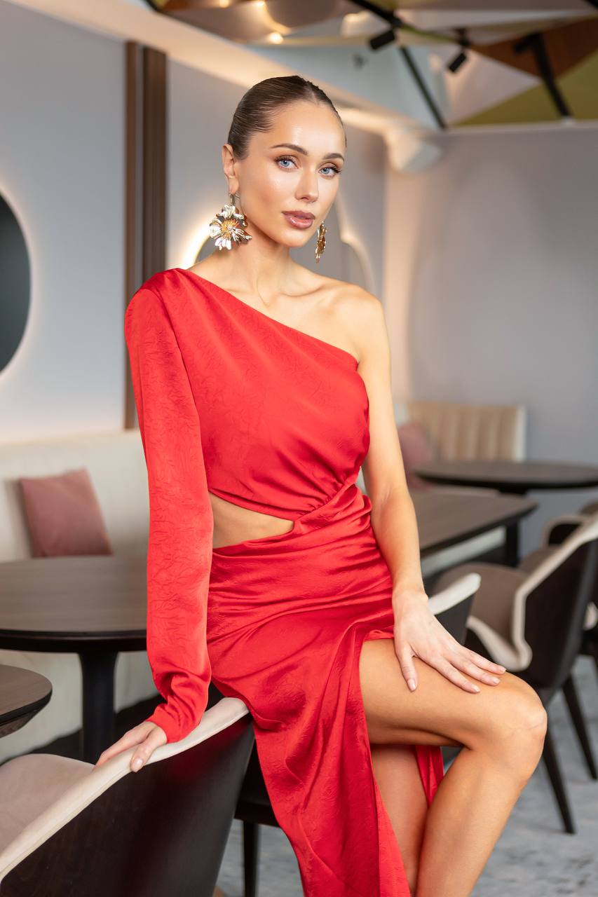 Woman in a red dress sitting in a modern cafe.