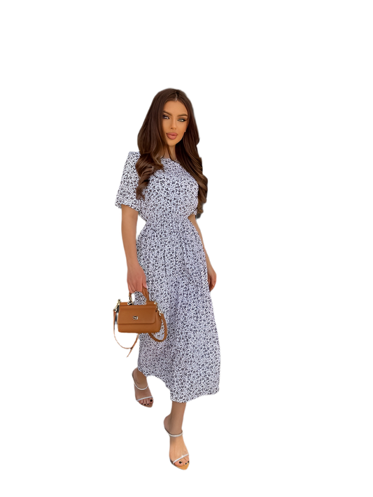 Woman wearing a floral dress holding a brown handbag on a white background