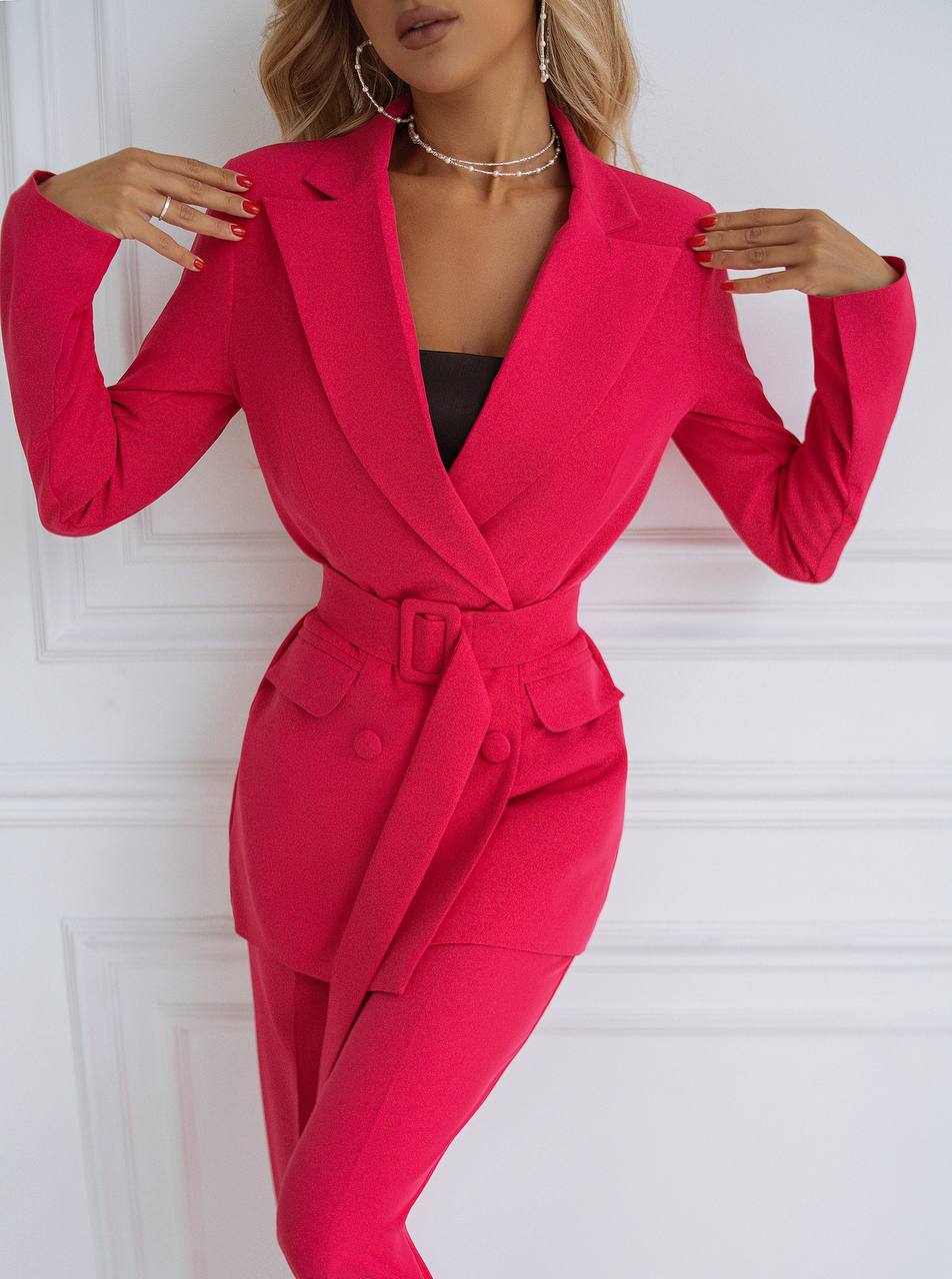 Person wearing a bright pink suit against a white background