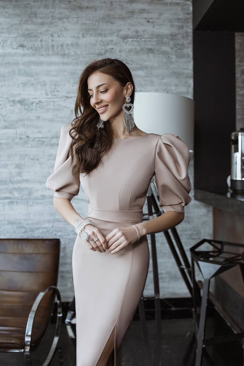 Woman in a stylish dress standing in an indoor setting
