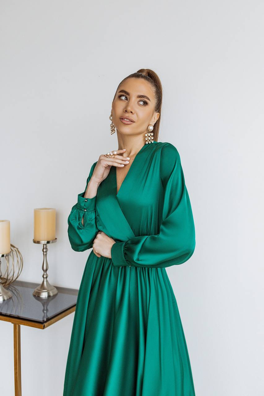 Woman wearing a green dress with candles and a table in the background