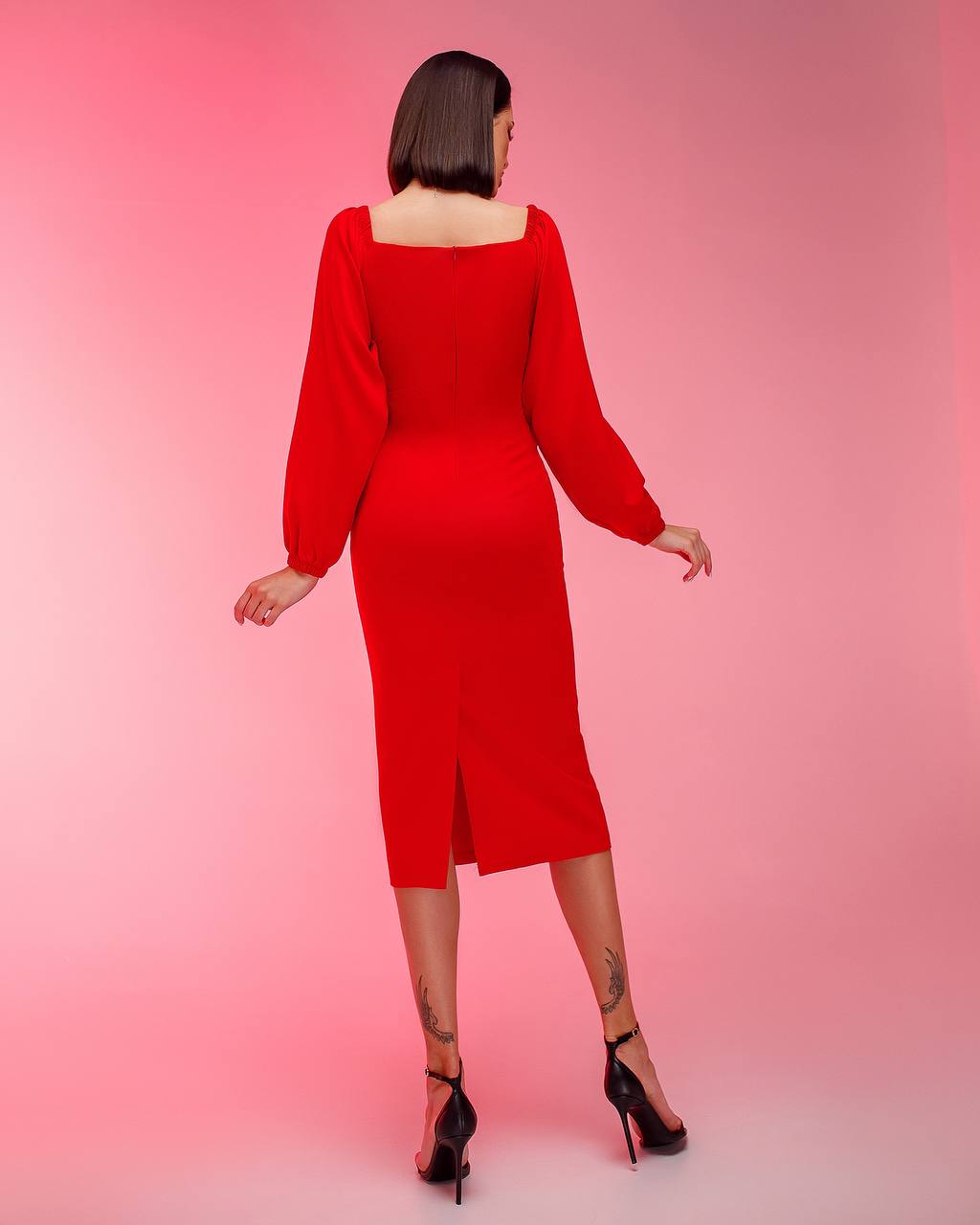 Woman wearing a red dress against a pink background