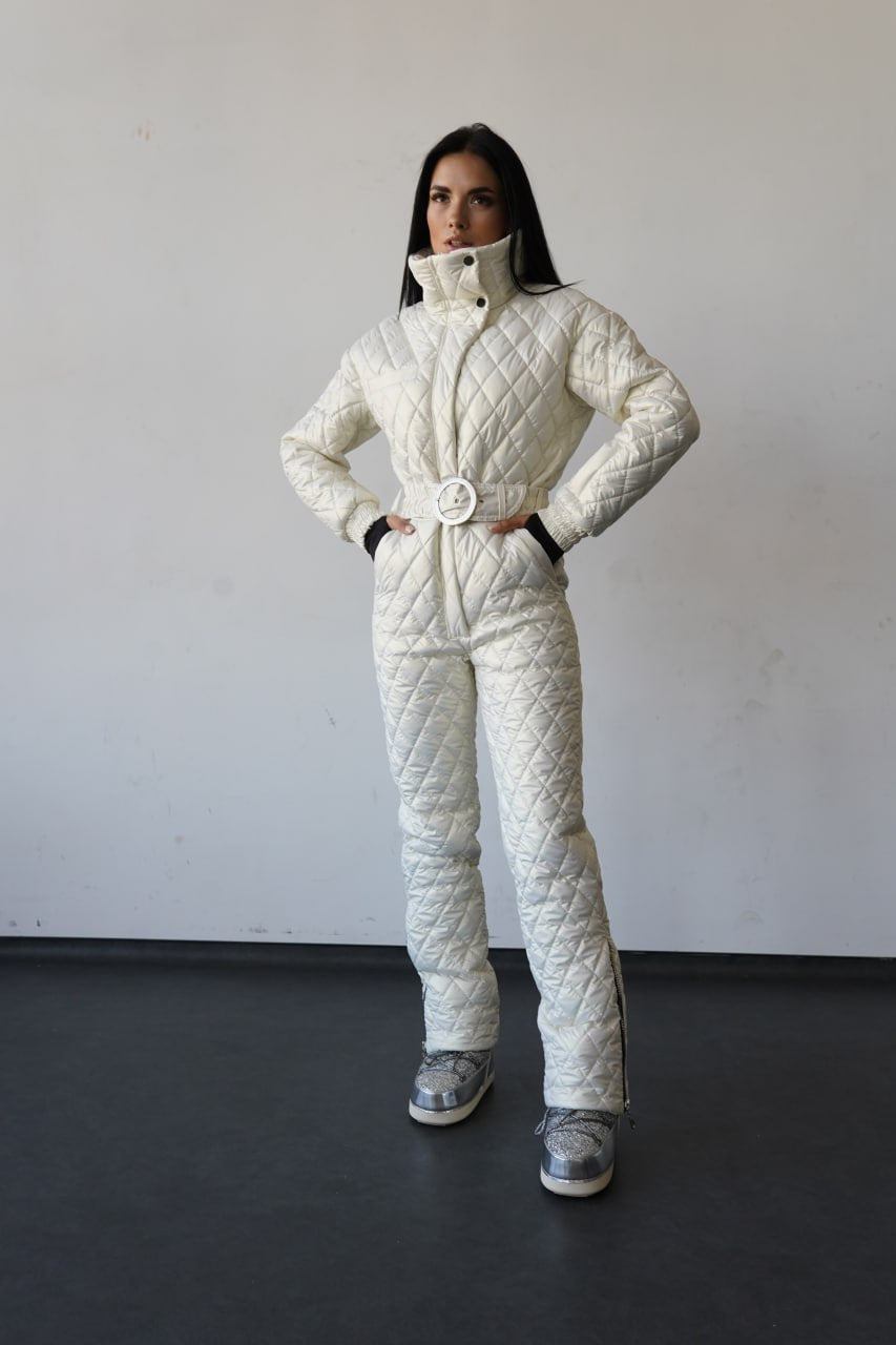 Person wearing a white quilted snowsuit against a plain background