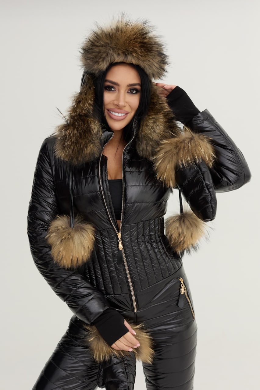 Woman wearing a black quilted jacket with fur trim on a white background