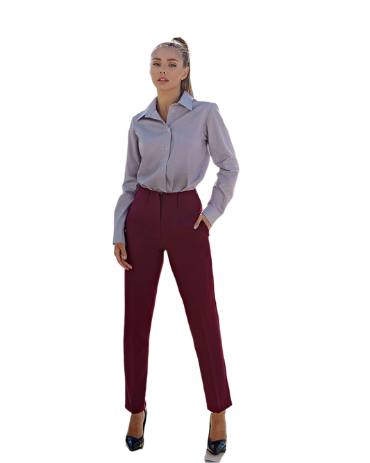 Woman wearing a light gray blouse and maroon pants on a white background