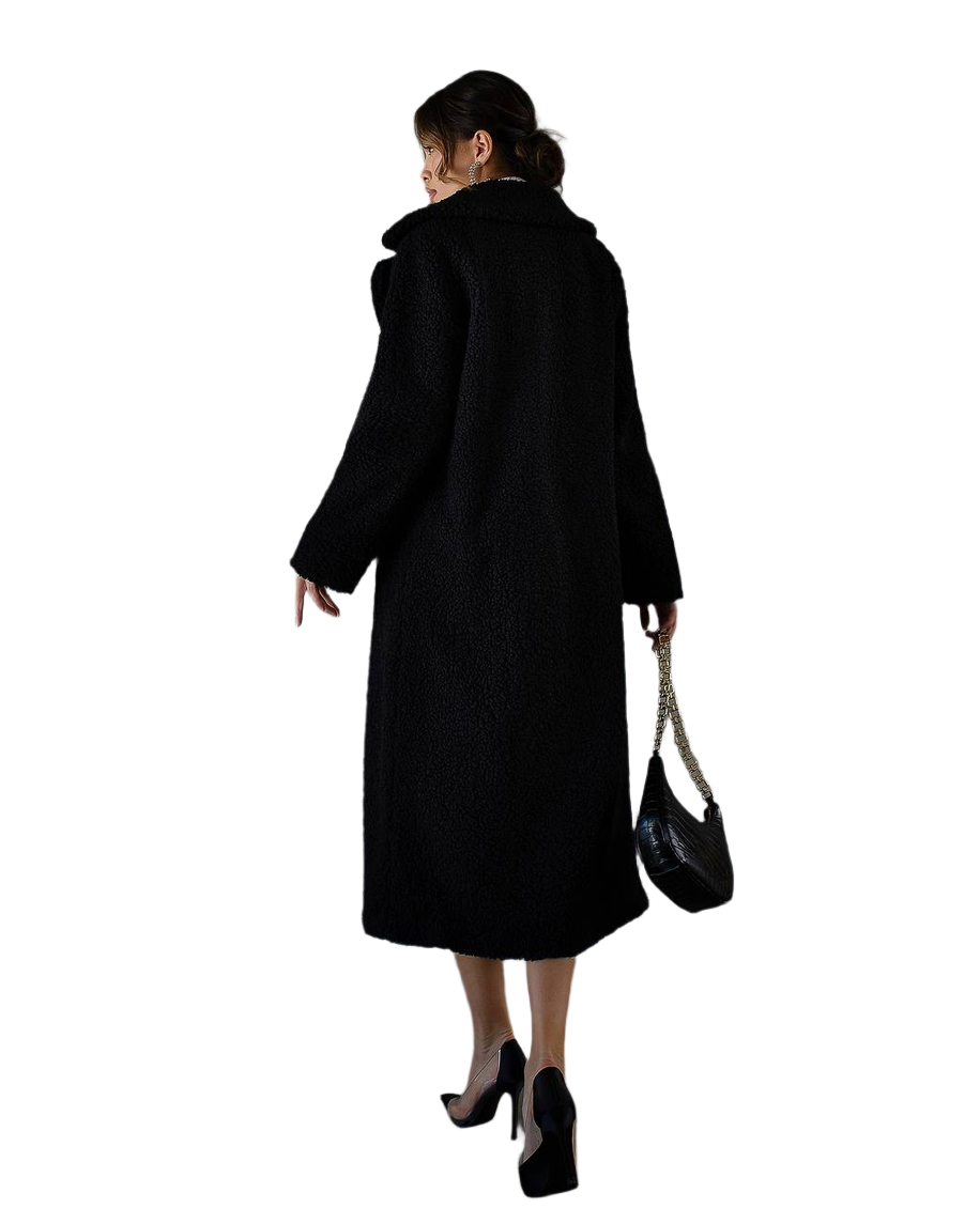 Woman wearing a black coat holding a black handbag on a white background