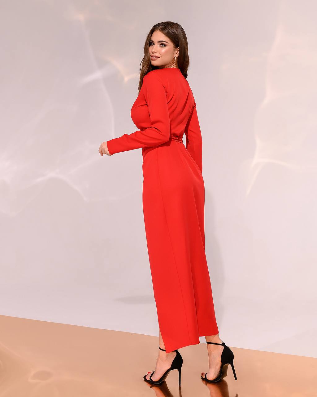Woman wearing a red dress against a neutral background