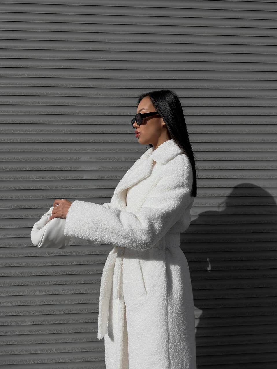 Woman wearing a white robe against a gray background