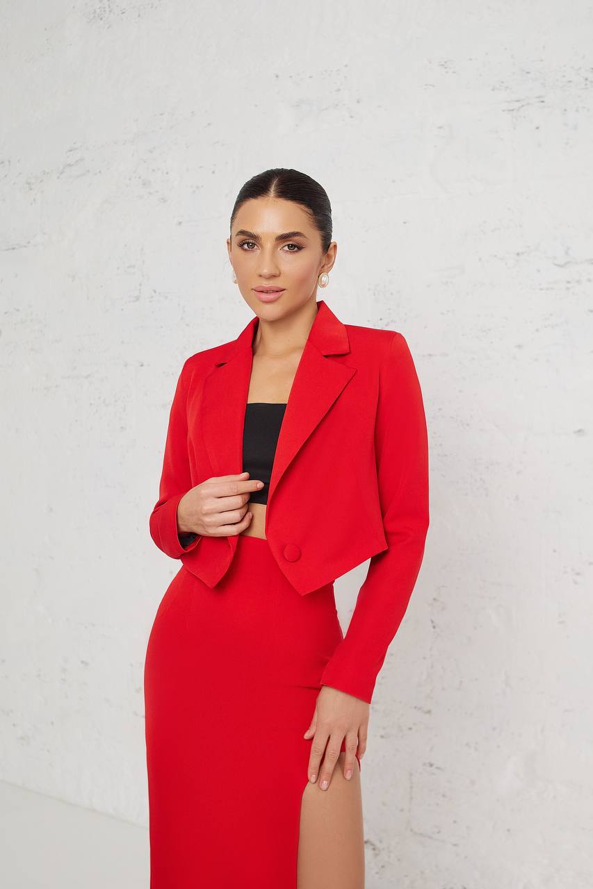Woman wearing a red outfit with a black top against a white background