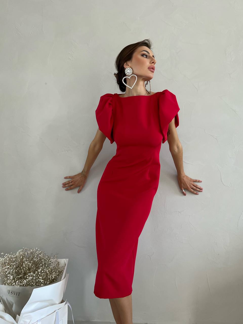 Woman in a red dress posing against a plain background