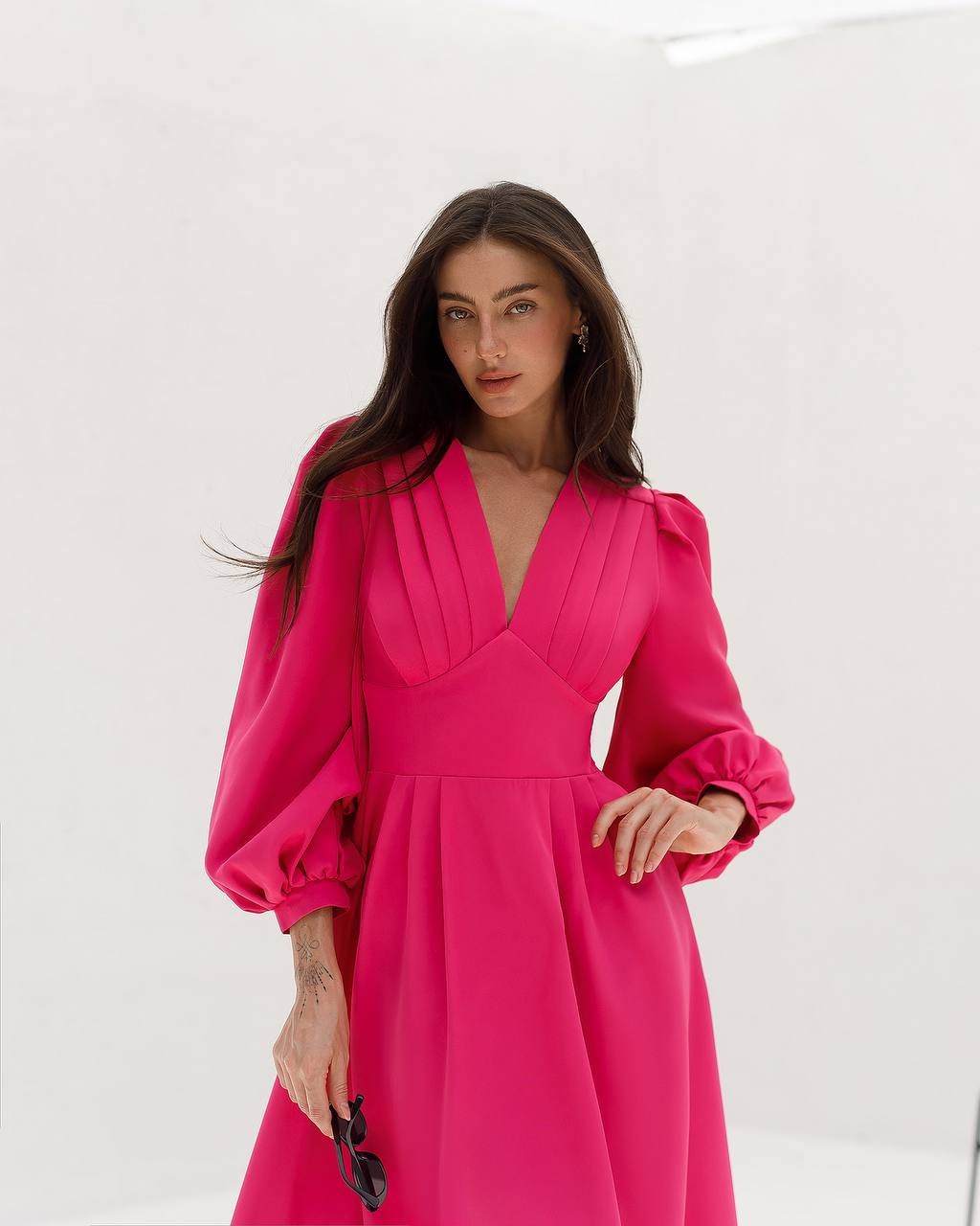 Woman wearing a bright pink dress against a white background