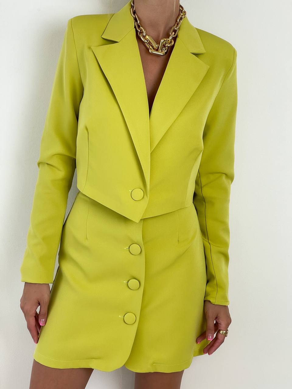 Person wearing a bright green suit with a plain background