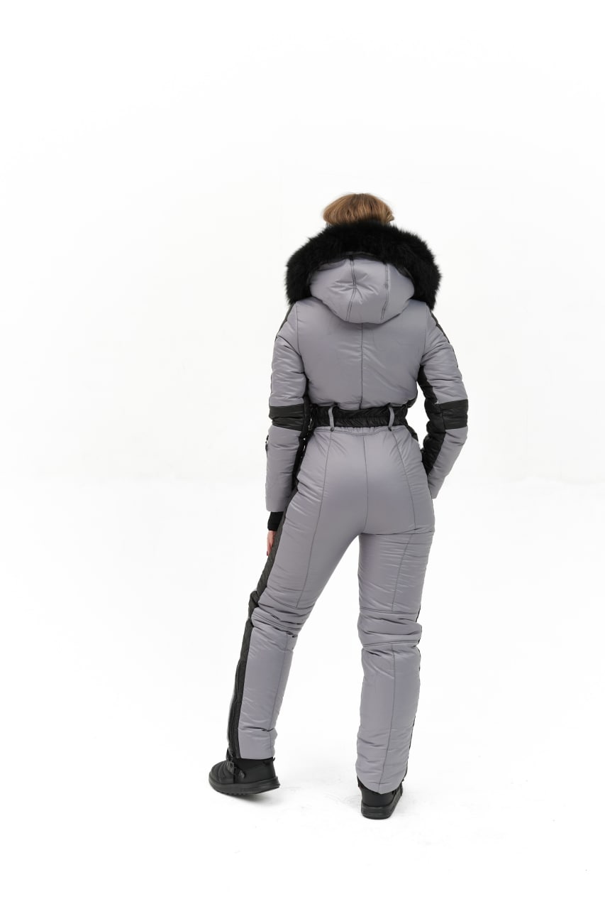 Person wearing a gray winter suit with black accents on a white background