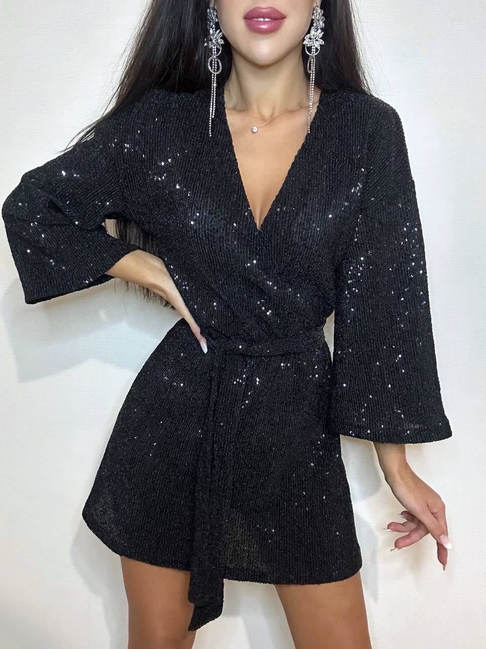 Black sequin romper worn by a model on a white background