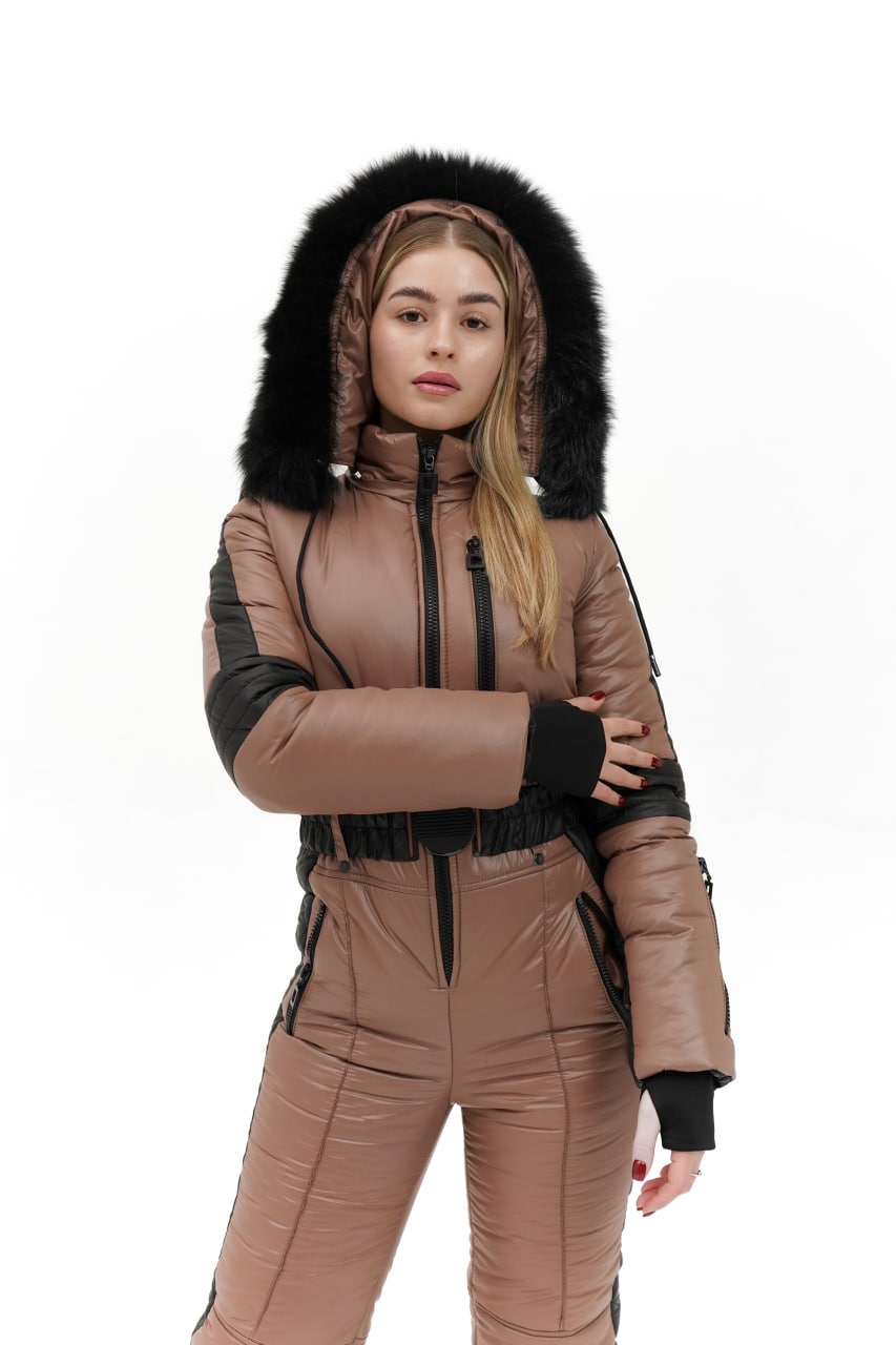 Woman wearing a brown snowsuit with black fur hood on a white background